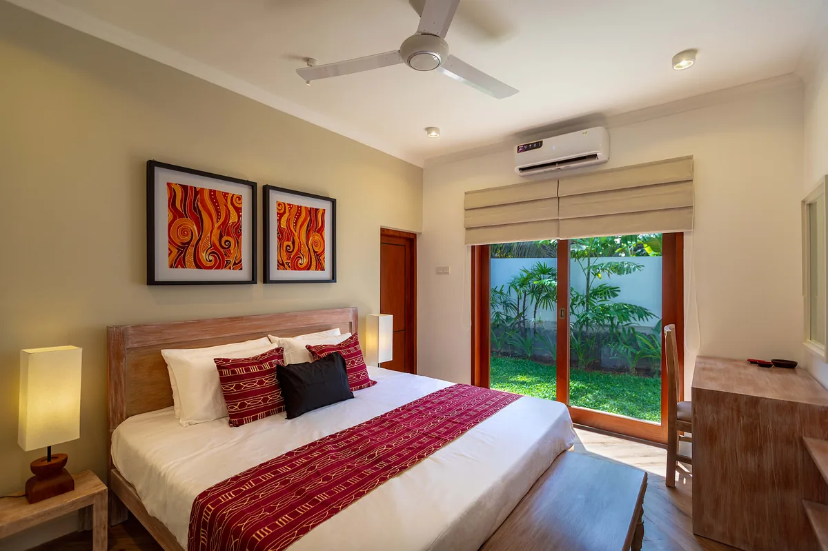 Saffron Suite King Bed with Warm Red Batik Art and Garden Courtyard
